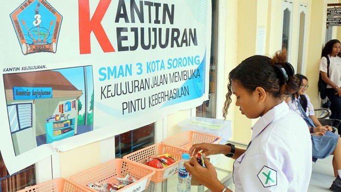 Seorang siswa berbelanja di kantin kejujuran SMA Negeri 3 di Kota Sorong, Papua Barat Daya, Senin (15/7/2024). Sekolah tersebut menerapkan kantin kejujuran dengan menempatkan berbagai makanan dan minuman ringan beserta harganya dan satu wadah untuk pembayaran guna melatih penerapan dan pembiasaan sikap jujur bagi para peserta didik. ANTARA FOTO/Olha Mulalinda/Spt.