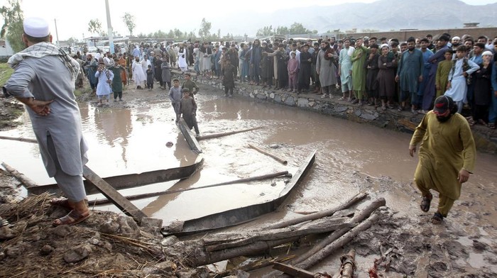 Banjir Bandang Terjang Afghanistan, 35 Orang Tewas People gather to clear the rubble of a house partially damaged by landslide due to heavy rainfall in Surkhroad district of Jalalabad, Nangarhar province east of Kabul, Afghanistan, Monday, July 15, 2024. (AP Photo/Shafiullah Kakar)
