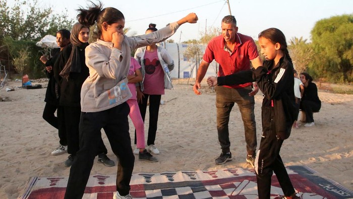 Girls train for boxing under Palestinian boxing coach Osama Ayoub near a tent camp sheltering displaced people, amid the Israel-Hamas conflict, in Khan Younis in the southern Gaza Strip, July 10, 2024. REUTERS/Hatem Khaled     TPX IMAGES OF THE DAY