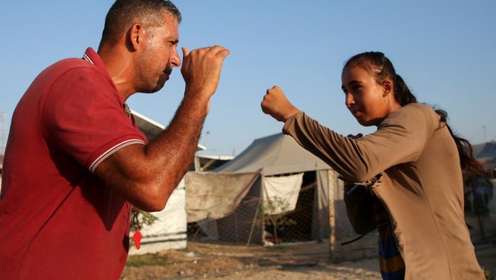 Girls train for boxing under Palestinian boxing coach Osama Ayoub near a tent camp sheltering displaced people, amid the Israel-Hamas conflict, in Khan Younis in the southern Gaza Strip, July 10, 2024. REUTERS/Hatem Khaled     TPX IMAGES OF THE DAY
