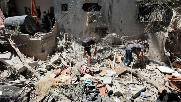 Palestinians inspect a house hit in an Israeli strike, amid the Israel-Hamas conflict, in Deir Al-Balah in the central Gaza Strip, July 15, 2024. REUTERS/Ramadan Abed
