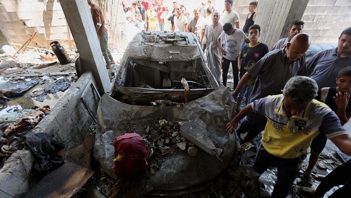 Palestinians inspect a house hit in an Israeli strike, amid the Israel-Hamas conflict, in Deir Al-Balah in the central Gaza Strip, July 15, 2024. REUTERS/Ramadan Abed