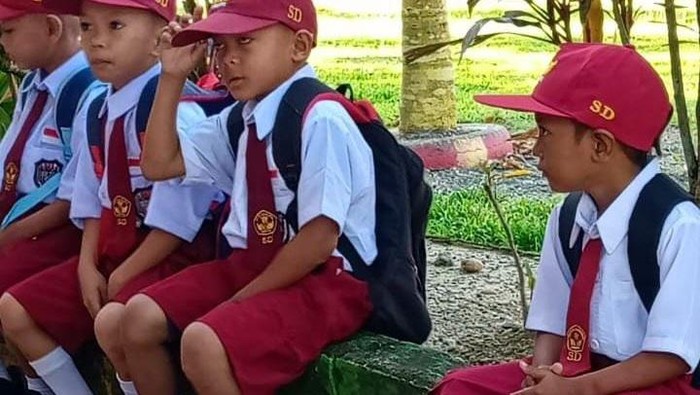 Muhammad Firdaus (kanan), siswa SD di Mamuju Tengah bersekolah menggunakan sendal jepit.