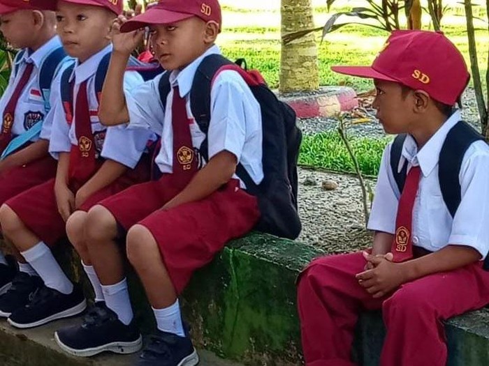 Muhammad Firdaus (kanan), siswa SD di Mamuju Tengah bersekolah menggunakan sendal jepit.