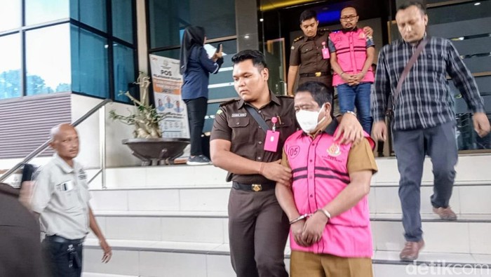 Munandar saat mengenakan rompi pink di Kejari Bondowoso.