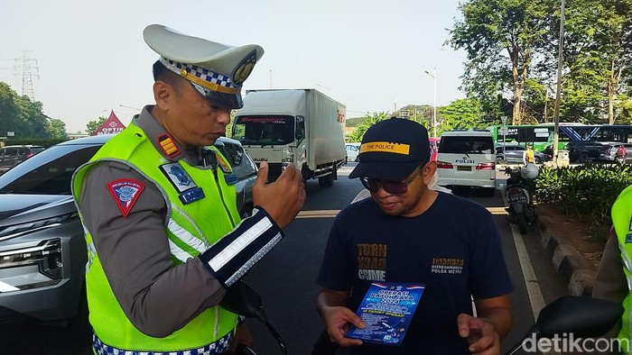 Pemotor tak menggunakan helm ditindak petugas dalam Operasi Patuh Jaya 2024. (Kurniawan Fadilah/detikcom)