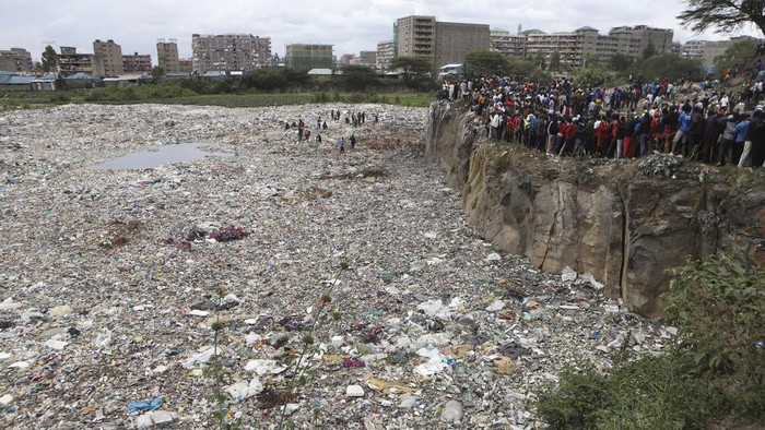 A man is lowered into a quarry where human remains were found in Mukuru kwa Njenga area, in Nairobi, Kenya Saturday, July 13, 2024. Police in Kenya said Monday they have arrested the main suspect after nine dismembered bodies of women were found in a quarry in the capital, Nairobi. (AP Photo/Andrew Kasuku)