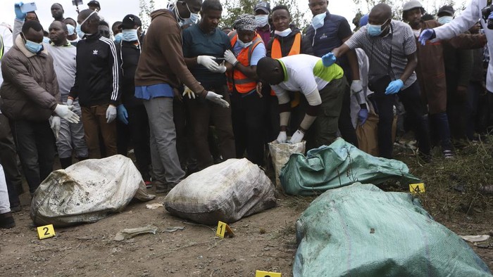 A man is lowered into a quarry where human remains were found in Mukuru kwa Njenga area, in Nairobi, Kenya Saturday, July 13, 2024. Police in Kenya said Monday they have arrested the main suspect after nine dismembered bodies of women were found in a quarry in the capital, Nairobi. (AP Photo/Andrew Kasuku)