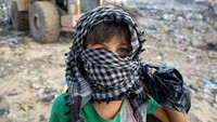 Anak ini mamakai penutup kepala untuk menghindari panas. 
