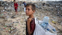 Seorang anak laki-laki Palestina mengais barang-barang yang bisa daur ulang di tempat pembuangan sampah, di tengah konflik Israel-Hamas, di Khan Younis di selatan Jalur Gaza, 15 Juli 2024. 
