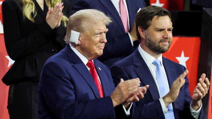 Republican presidential nominee and former U.S. President Donald Trump applauds with Republican vice presidential nominee J.D. Vance during Day 1 of the Republican National Convention (RNC) at the Fiserv Forum in Milwaukee, Wisconsin, U.S., July 15, 2024. REUTERS/Jeenah Moon