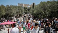 Wisatawan menuruni Acropolis, setelah ditutup sementara di tengah gelombang panas di Athena, Yunani, Rabu (17/7/2024). Pihak berwenang menutup situs populer tersebut dari pukul 12.00 hingga 17.00 (900 GMT hingga 1400 GMT), yang merupakan jam puncak cuaca panas bagi pengunjung.