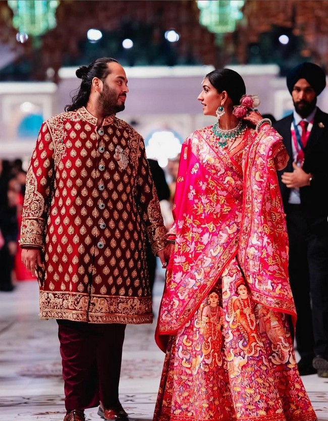 Di malam pertama setelah resmi menjadi suami-istri, Radhika dan Anant tampil megah dalam balutan busana bernuansa merah dan fuschia. Anant berbalut busana dari Manish Malhotra, sementara Radhika memilih rancangan Abu Jani Sandeep Khosla. Foto: Instagram/@shaleenanathani @storiesbyjosephradhik