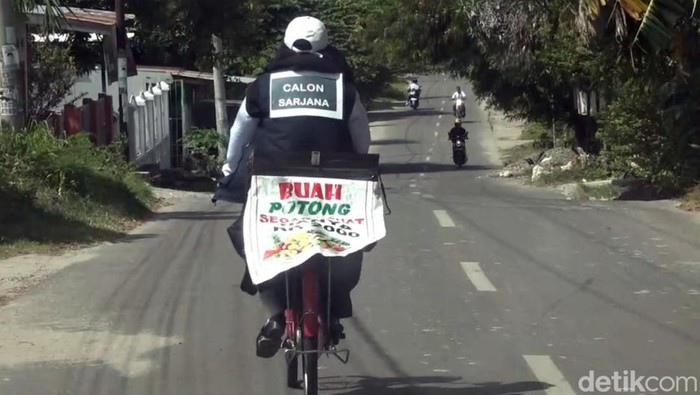 Andi Riza Ardia saat mengayuh sepeda berjuan buah.