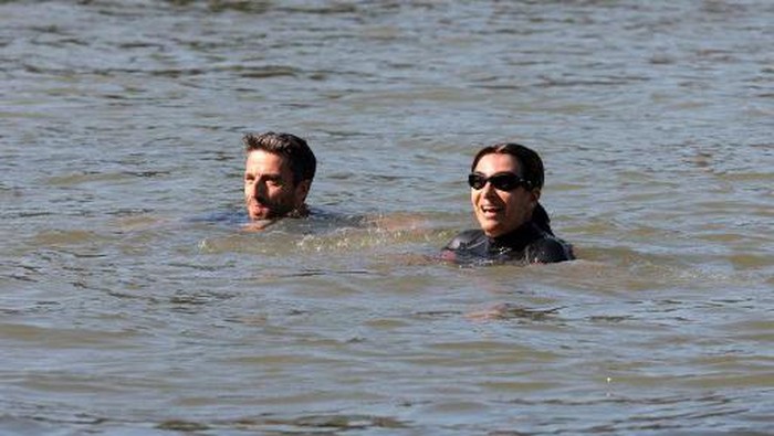 Paris Mayor Anne Hidalgo and President of the Paris 2024 Olympics and Paralympics Organising Committee (Cojo) Tony Estanguet (L) swim in the Seine, in Paris on July 17, 2024, to demonstrate that the river is clean enough to host the outdoor swimming events at the Paris Olympics later this month. Despite an investment of 1.4 billion euros ($1.5 billion) to prevent sewage leaks into the waterway, the Seine has been causing suspense in the run-up to the opening of the Paris Games on July 26 after repeatedly failing water quality tests. But since the beginning of July, with heavy rains finally giving way to sunnier weather, samples have shown the river to be ready for the open-water swimming and triathlon -- and for 65-year-old Hidalgo. (Photo by JOEL SAGET / POOL / AFP)