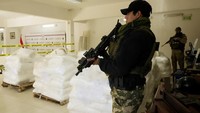 Agen dari badan anti-narkoba Paraguay, Senad, menjaga karung kokain di pelabuhan Caacupemi di Asuncion, Paraguay, Selasa (16/7/2024).  
