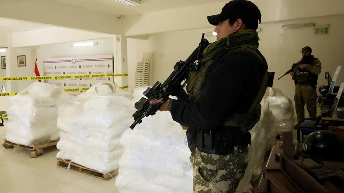 Agents from Paraguay’s anti-drug agency, Senad, guard sacks of cocaine at the Senad headquarters after the drugs were seized at the port of Caacupemi in Asuncion, Paraguay, Tuesday, July 16, 2024. Authorities announced the largest cocaine seizure in the country's history after officials found more than 4 tons of the drug stashed inside a shipment of sugar bound for Belgium. (AP Photo/Jorge Saenz)