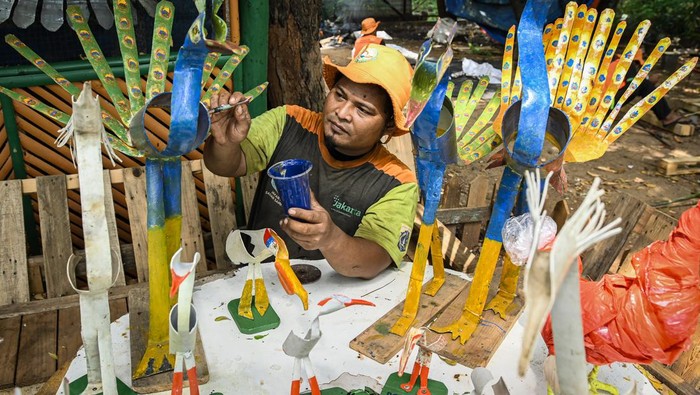 Petugas Unit Pengelolaan Sampah (UPS) membuat dekorasi dari botol plastik ecobrick di Taman Waduk Cincin, Tanjung Priok, Jakarta, Rabu (17/7/2024). UPS Tanjung Priok memanfaatkan sampah botol plastik, kemasan plastik dan paralon untuk dijadikan dekorasi penataan kawasan Taman Waduk Cincin. ANTARA FOTO/Sulthony Hasanuddin/nym.