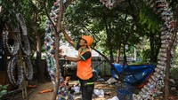 Petugas Unit Pengelolaan Sampah (UPS) membuat dekorasi dari botol plastik ecobrick di Taman Waduk Cincin, Tanjung Priok, Jakarta, Rabu (17/7/2024).