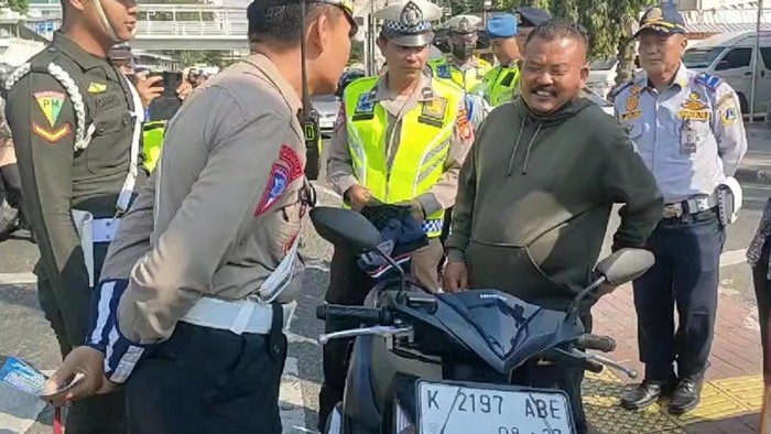 Seorang pria ditegur polisi karena tidak memakai helm dengan alasan ketinggalan.