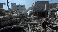 Warga Palestina terlihat mengobrak-abrik puing-puing di area yang rusak, ada yang membersihkannya dan ada yang mencari barang-barang.