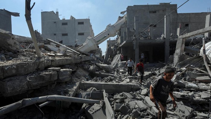 Palestinians inspect the site of an Israeli strike on Abdullah Azzam mosque, amid the Israel-Hamas conflict, in Nuseirat refugee camp in the central Gaza Strip, July 17, 2024. REUTERS/Ramadan Abed