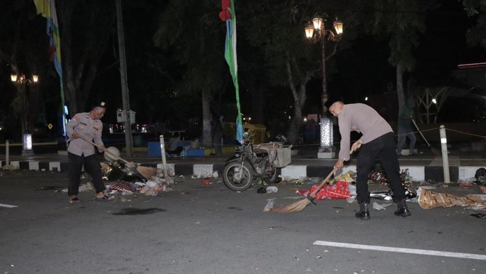 Anggota Polres Lamongan membersihkan sampah sisa acara