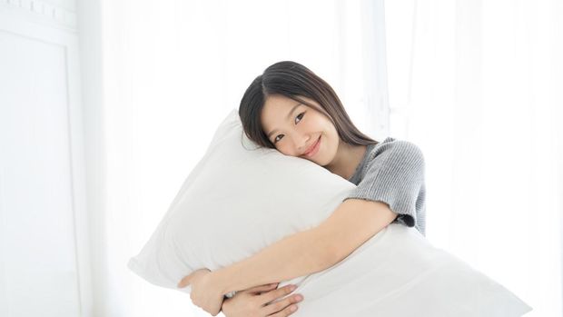 Portrait Asian woman and pillow wake up on bed at home