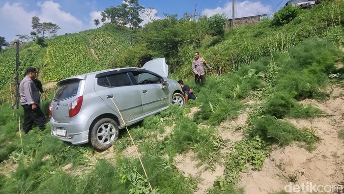Mobil terperosok ke ladang warga di jalur SSB, Boyolali, hendak dievakuasi Kamis (18/7/2024).