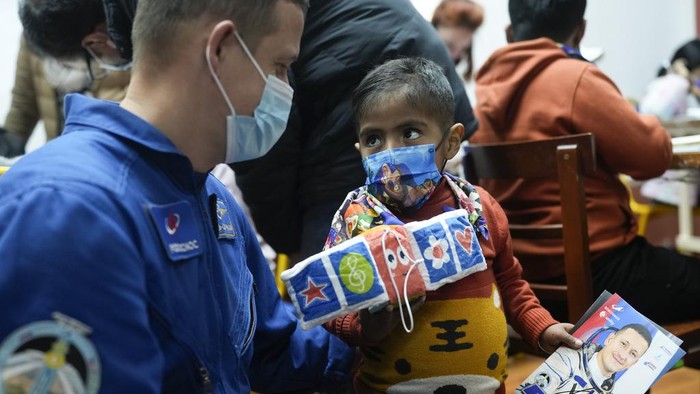 A young cancer patient creates art depicting their family to give to Russian astronaut Sergey Kud-Sverchkov who is visiting the Dr. Ovidio Aliaga Uria Children's Hospital in La Paz, Bolivia, Wednesday, July 17, 2024. (AP Photo/Juan Karita)