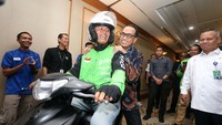 Menteri Perhubungan (Menhub) Budi Karya Sumadi tampak ceria saat dibonceng oleh seorang pengumudi ojek online di Jakarta, Rabu (17/7). 