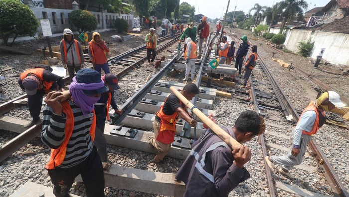 Pekerja memasang bantalan rel saat pengerjaan penggantian wesel rel kereta api di Kota Kediri, Jawa Timur, Rabu (17/7/2024). Penggantian wesel atau sistem mekanik untuk memindahkan jalur pada persimpangan rel kereta api tersebut dilakukan PT Kereta Api Indonesia (Persero) Daop 7 untuk meningkatkan kenyamanan dan keselamatan perjalanan kereta api. ANTARA FOTO/Prasetia Fauzani/tom.