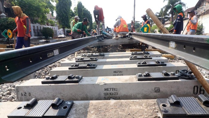 Penggantian wesel kereta api di Kediri Pekerja memasang bantalan rel saat pengerjaan penggantian wesel rel kereta api di Kota Kediri, Jawa Timur, Rabu (17/7/2024). Penggantian wesel atau sistem mekanik untuk memindahkan jalur pada persimpangan rel kereta api tersebut dilakukan PT Kereta Api Indonesia (Persero) Daop 7 untuk meningkatkan kenyamanan dan keselamatan perjalanan kereta api. ANTARA FOTO/Prasetia Fauzani/tom.