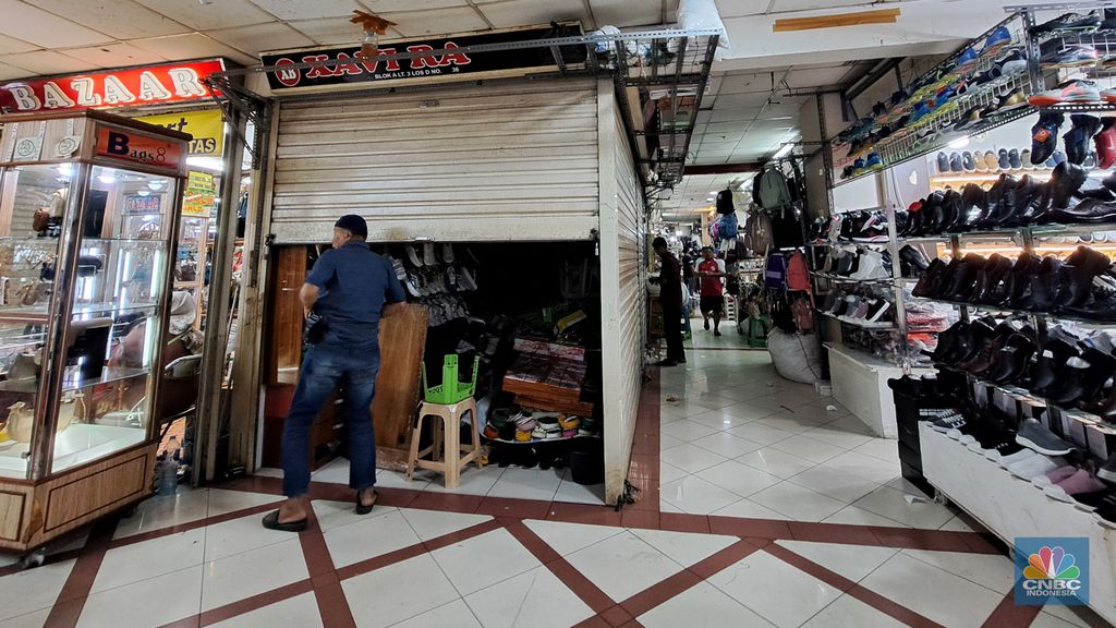 Penjual sepatu merapihkan dagangannya sebelum menutup toko di Blok A asar Tanah Abang, Jakarta, Kamis (18/7/2024). Sejumah pedagang Blok A Pasar Tanah Abang khususnya di lantai 3  Blok A mengaku tengah dilanda kepanikan karena khawtir akan adanya razia barang impor. (վ/Faisal Rahman)