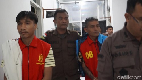 Penyidik Kejati NTT menggiring kedua tersangka tindak pidana korupsi penyelenggaraan cadangan beras pemerintah (CBP) pada Perum Bulog Kantor Cabang Waingapu, Kamis (18/7/2024). (Foto: Simon Selly/detikBali)