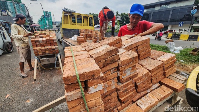 Potret Buruh Harian Lepas di Jakarta Buruh harian lepas menurunkan bata merah dalam proyek bangunan rumah di Jl Tambak, Jakarta Selatan, Kamis (17/7/2024). Para buruh ini mengaku dibayar Rp 85.000/hari. Jumlah tersebut terbilang pas-pasan untuk standar upah layak di Jakarta.