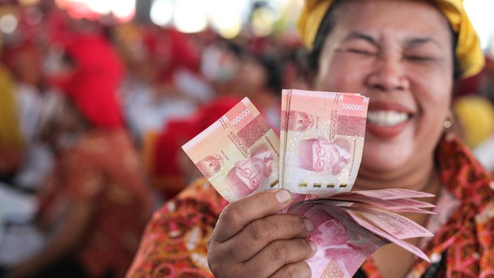 Seorang buruh pabrik rokok menunjukkan uang tunai yang didapatnya dari pencairan Bantuan Langsung Tunai (BLT) Dana Bagi Hasil Cukai Tembakau (DBHCT) Tahun 2024 di PT HM Sampoerna Tbk Plant Rungkut 2, Surabaya, Jawa Timur, Kamis (18/7/2024). Pemerintah Kota Surabaya menyalurkan Bantuan Langsung Tunai (BLT) Dana Bagi Hasil Cukai Tembakau (DBHCT) Tahun 2024 kepada 9.370 Keluarga Penerima Manfaat (KPM) senilai Rp1,4 juta per penerima di Surabaya. ANTARA FOTO/Didik Suhartono/foc.