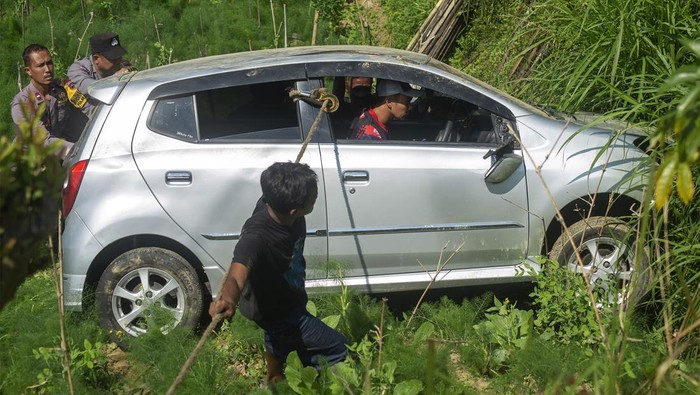 Warga dan polisi mengevakuasi mobil yang mengalami kecelakaan masuk ladang di lereng Gunung Merapi, Cepogo, Boyolali, Jawa Tengah, Kamis (18/7/2024). Kecelakaan tunggal mobil dengan nomor polisi AD 1040 MZ itu disebabkan karena sopir kurang konsentrasi saat mengemudi sementara itu empat orang penumpang selamat dalam peristiwa tersebut. ANTARA FOTO/Aloysius Jarot Nugroho/aww.