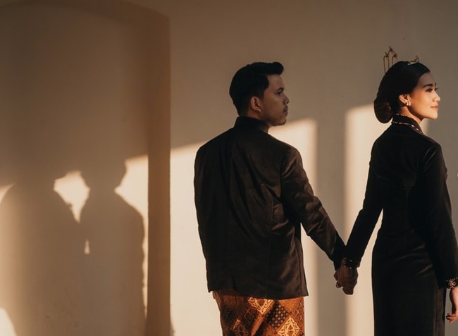 Busana adat Jawa berwarna hitam itu dipadukan dengan kain lilit batik berwarna coklat. Pasangan sejoli tersebut juga tampak memamerkan kemesraan mereka. Foto: Instagram/@thariqhalilintar