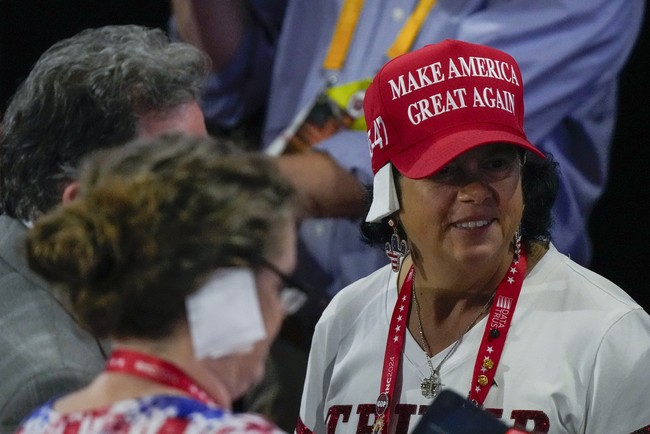 Besoknya saat hajatan Partai Republik itu berlanjut, para pendukung setia Trump berbondong-bondong datang dengan kuping yang seakan ditutup perban putih. Mereka memakai perban versinya masing-masing. (Foto: AP Photo/Matt Rourke)