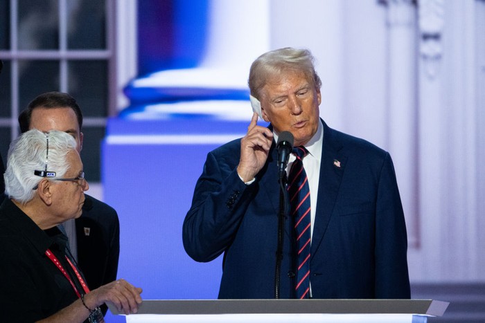UNITED STATES - JULY 17: Former President Donald Trump touches his injured ear during his podium check at the Fiserv Forum before the start of the session of the Republican National Convention in Milwaukee on Wednesday, July 17, 2024. (Bill Clark/CQ-Roll Call, Inc via Getty Images)