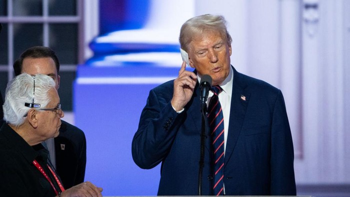 UNITED STATES - JULY 17: Former President Donald Trump touches his injured ear during his podium check at the Fiserv Forum before the start of the session of the Republican National Convention in Milwaukee on Wednesday, July 17, 2024. (Bill Clark/CQ-Roll Call, Inc via Getty Images)