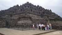 Sekelompok wisatawan mancanegara yang serius menyimak penjelasan dari pemandu wisata