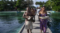 Seusai pemberkatan, mulai diaraklah sesaji dengan berjalan kaki sekitar 500 meter menuju dermaga Kampung Friwen agar proses pemasangan sistem tambat kapal berjalan lancar.  