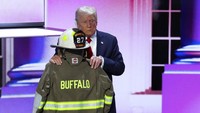Trump menghampiri seragam pemadam kebakaran yang menurut pihak berwenang milik korban penembakan rapat umum Corey Comperatore. Seragam itu bertuliskan Buffalo dan Compertore. REUTERS/Mike Segar