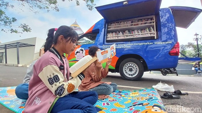 Anak-anak asyik membaca buku dari perpustakaan keliling di Alun-alun Dadaha Kota Tasikmalaya.