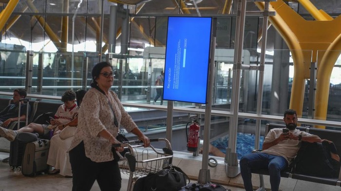 A screen shows a Microsoft Windows recuperation message at Barajas international airport in Madrid, Spain, Friday, July 19, 2024. A global technology outage grounded flights, knocked banks offline and media outlets off air on Friday. (AP Photo/Paul White)