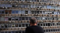 Seorang pria melihat sebuah bangunan yang rusak akibat ledakan di Tel Aviv, Israel, Jumat (19/7/2024).