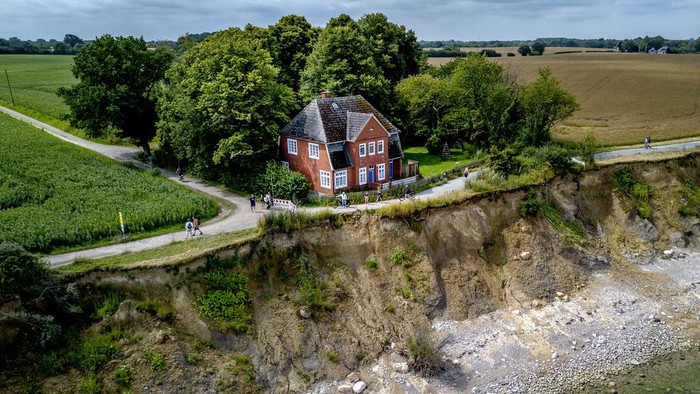 An abandoned house stands near the eroding bank of Brodten near Travemuende at the Baltic Sea, Germany, Thursday, July 18, 2024. The house that hosted young people during vacations was closed down due to safety reasons. (AP Photo/Michael Probst)