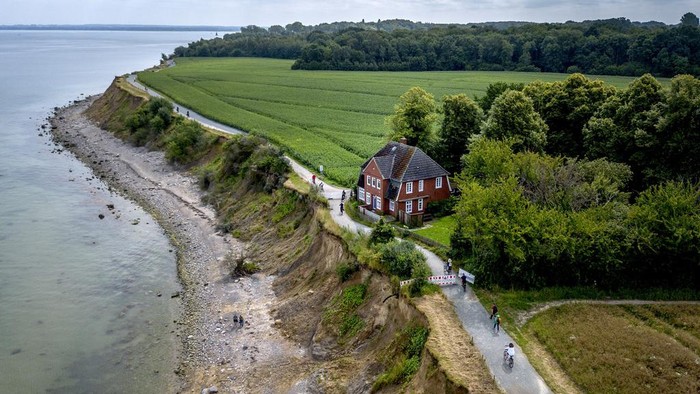 Penampakan Villa Terbengkalai di Jerman Karena Terancam Longsor An abandoned house stands near the eroding bank of Brodten near Travemuende at the Baltic Sea, Germany, Thursday, July 18, 2024. The house that hosted young people during vacations was closed down due to safety reasons. (AP Photo/Michael Probst)